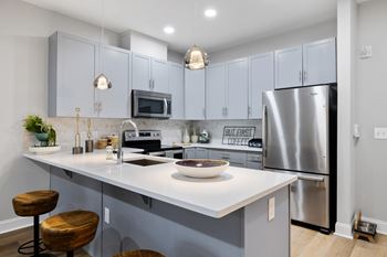 Contemporary kitchen with white quartz countertops and island